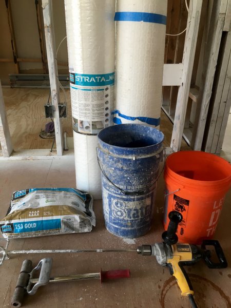 plastic underlayment for tile floor, a mixing bucking, thinset and electric drill